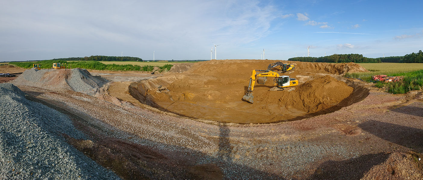 Aushubarbeiten mit zwei Kettenbaggern, hier wird eine Baugrube für das Fundament einer Windkraftanlage erstellt.