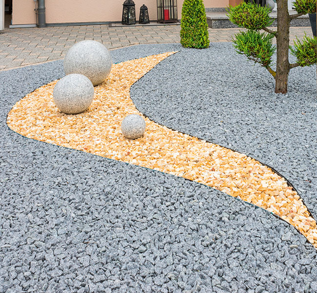 Moderner Steingarten Geschwungene Kiesbeete mit Kugeln als Designelemente ist eine Variante bei Pflasterarbeiten.